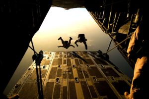 Two people jump from the back of a plane