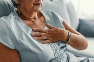 Woman holding chest with suspected heart attack