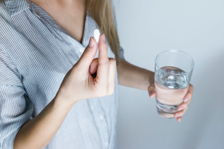 Woman swallowing a pill with a glass of water