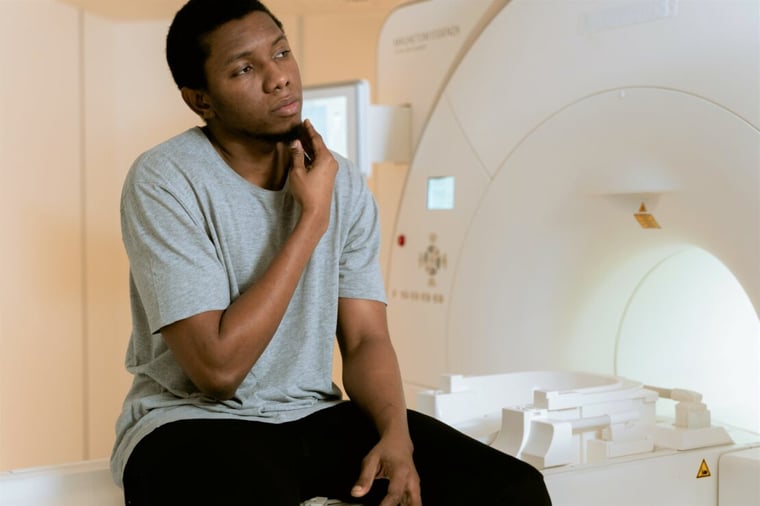 man sat on MRI scanner