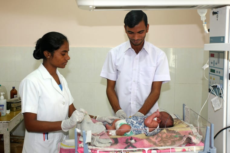 doctor and nurse with baby in incubator