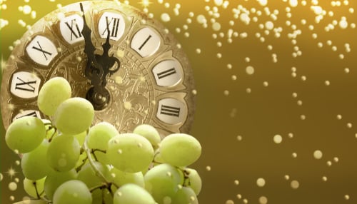 Bunch of green grapes in front of a clock 