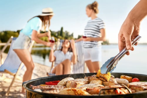 Bbq on beach with women in background