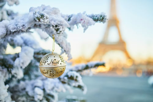 Noel bauble on a snow covered tree with the Eiffel Tower in the background